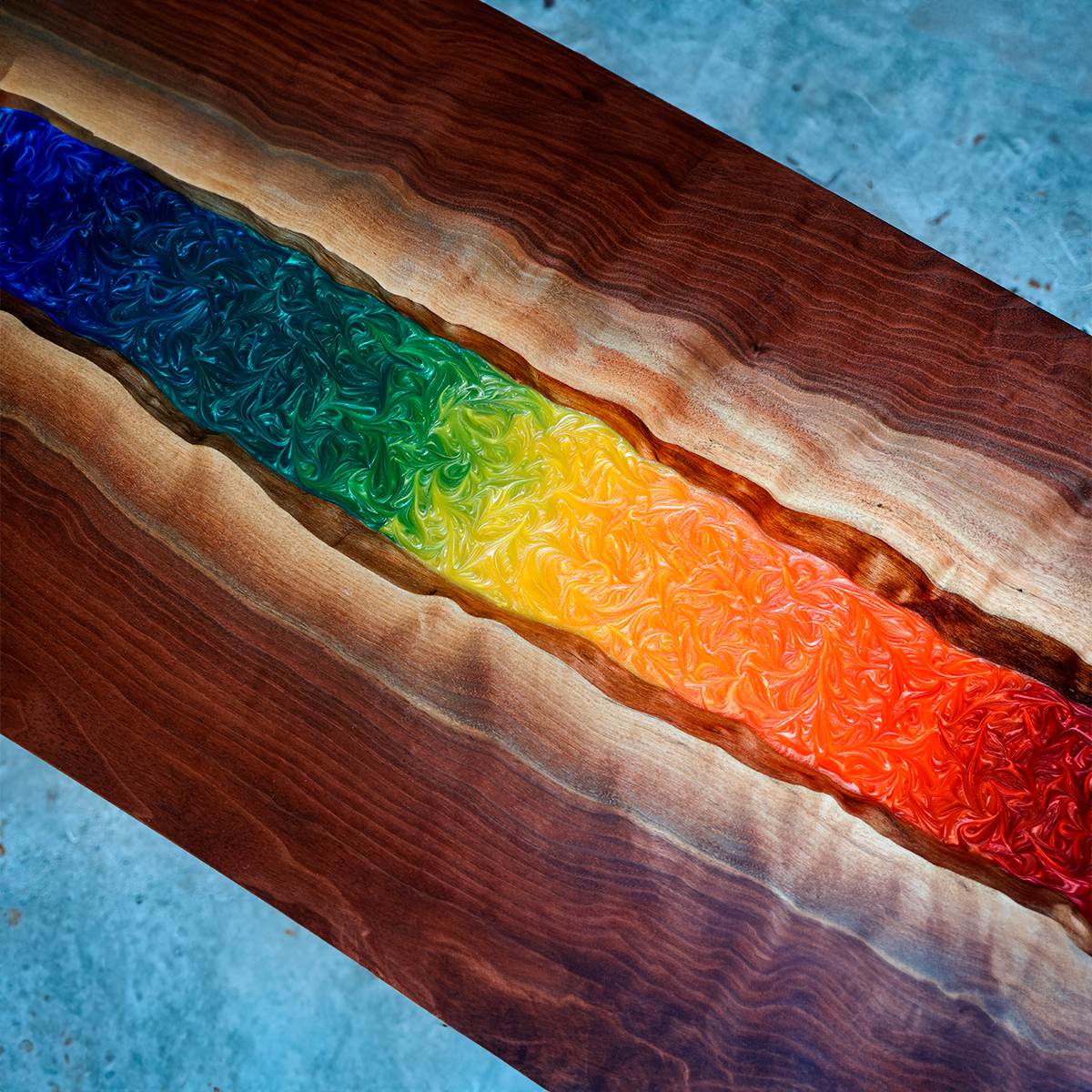 Colorful Epoxy Resin River Table with a rainbow swirl pattern down the center.